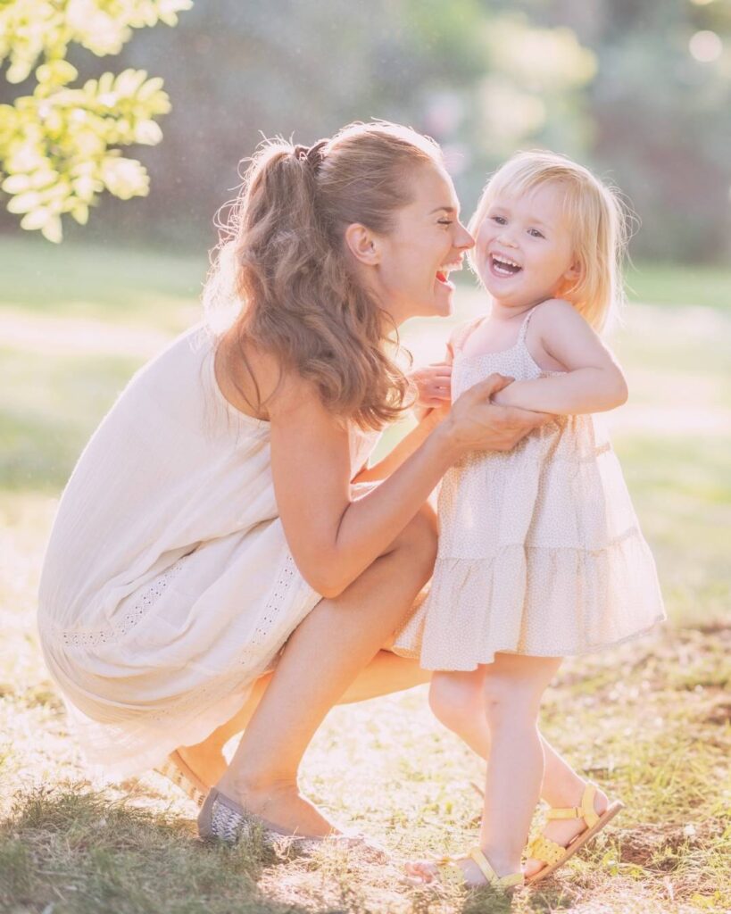 happy mum entrepreneur playing with her daughter after getting out of her business owner burnout